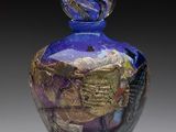 une photo d'un vase en verre bleu orné de feuilles d'or