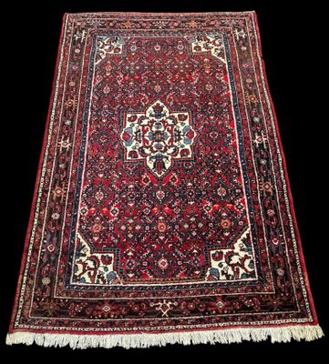 un tapis persan ancien orné d'un motif en médaillon sur fond noir
