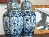 two blue and white vases sitting on a table