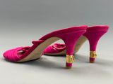 une paire de chaussures à talons hauts roses ornées de boucles dorées