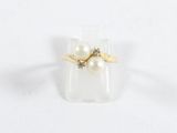 une image d'une bague en perles et diamants sur une surface blanche