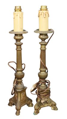 pair of antique brass candlesticks with candles on top of them