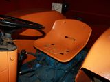 an orange tractor with a steering and a steering wheel