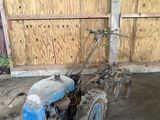 un tracteur bleu garé à l'intérieur d'un bâtiment