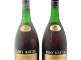 two bottles of wine sitting next to each other on a white surface