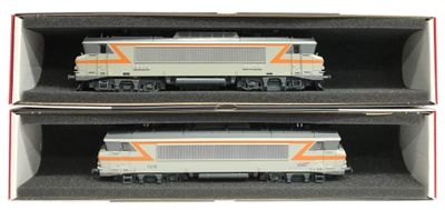 deux trains miniatures posés dans une boîte sur la table