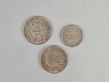 three different types of coins are shown on a white surface