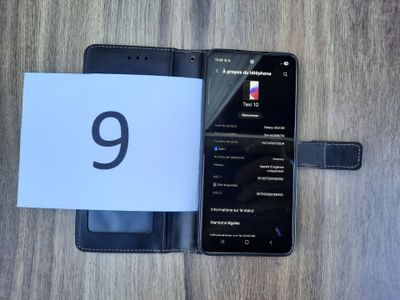 an image of a cell phone sitting next to a notepad on a wooden table