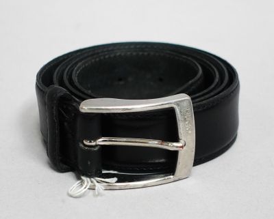 une ceinture noire ornée d'une boucle argentée sur un fond blanc