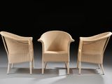 pair of wicker lounge chairs with arms and backrests