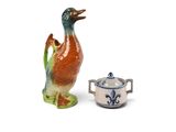 une petite figurine d'oiseau à côté d'une théière