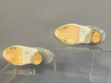 two pairs of shoes that are on display in a case