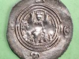 a silver coin with an image of a woman holding a child