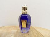 an image of a bottle of perfume sitting on a wooden table