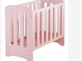 a baby crib with a pink bed and a white background
