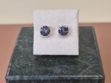 une paire de boucles d'oreilles en saphir bleu posée sur un bloc de marbre