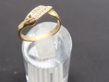 un gros plan d'une bague en or posée sur un verre transparent