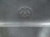 a close up of a black leather purse with a lion emblem on it
