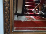 a reflection of a man in a mirror on a red carpet