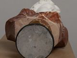 a sculpture of a rock on a table with a piece of paper on top of it