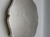 an antique silver plate mounted on a wall with a mirror