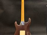 an electric guitar sitting on top of a wooden stand next to a guitar