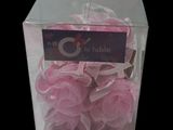 a clear box with a bunch of pink lollipops in it