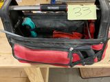 une sacoche à outils contenant des outils, posée sur un établi