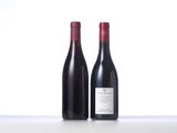 two bottles of red wine sitting next to each other on a table