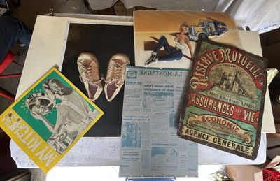 une table sur laquelle sont posées plusieurs vieilles affiches