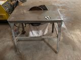 une table sur laquelle est posée une scie, dans un garage