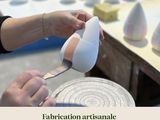 a woman that is making a vase out of clay