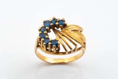 an image of a gold ring with blue stones on it