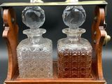 an old fashioned glass decanter set with a wooden stand