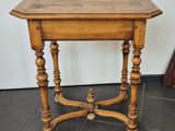 an old wooden table with a wooden top on a tiled floor