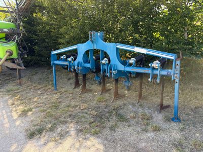 une machine bleue qui est posée dans l'herbe