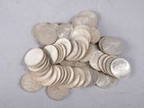 a pile of silver coins sitting on a white surface