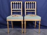 une paire de chaises anciennes dont les assises sont recouvertes d'un tissu à motifs floraux, sur fond bleu