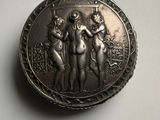 an antique silver pocket watch with three women on it