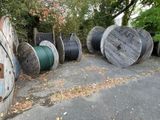 a lot of old wooden spools sitting on the ground