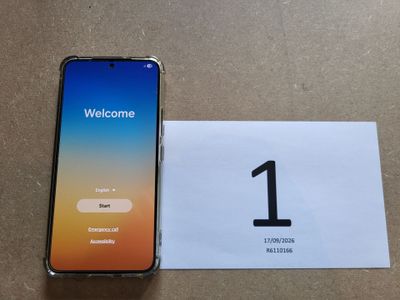 un téléphone posé sur une table, à côté d'une carte de bienvenue