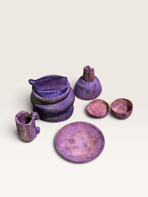 un ensemble de plats et de bols violets posés sur un plan de travail blanc