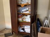 a closet full of clothes in a room with a lot of boxes
