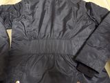 the back of a black jacket on a wooden table