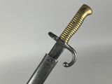 a close up of a sword on a white surface