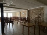 tables and chairs are lined up in a room with a stone wall