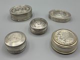 six types différents de pièces d'argent posées sur une table