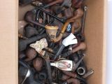 a cardboard box filled with assorted pipes and other items
