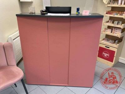 un comptoir rose sur lequel est posé un ordinateur portable