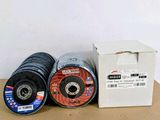 trois types différents de disques à meuler dans une boîte posée sur une table